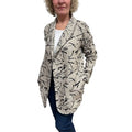 Woman wearing a patterned beige cardigan on a white background