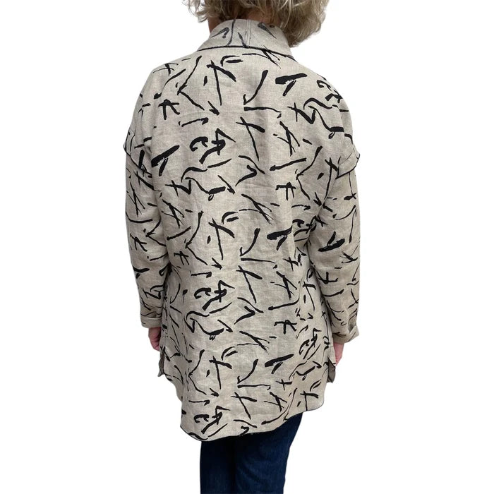 Person wearing a beige jacket with black abstract pattern on a white background