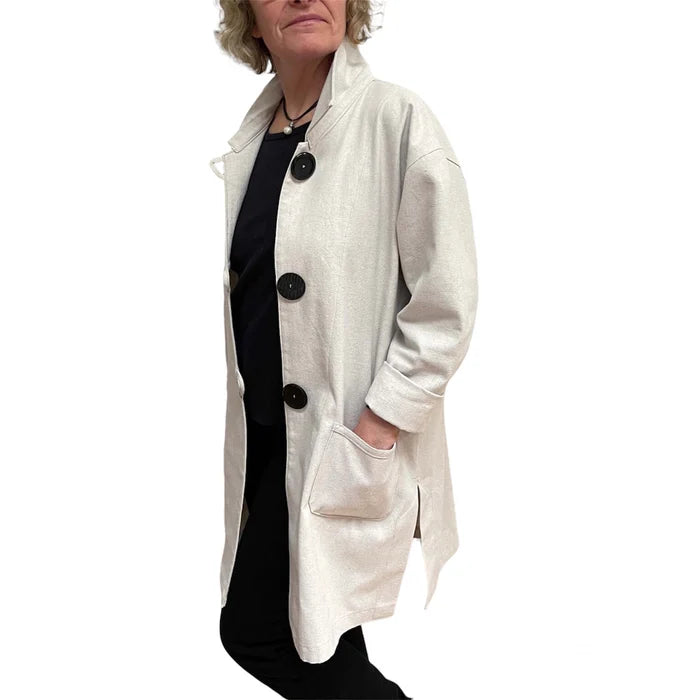 Person wearing a light gray coat with black buttons on a white background