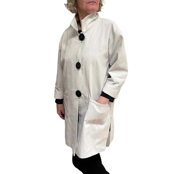 Person wearing a white coat with black buttons on a white background