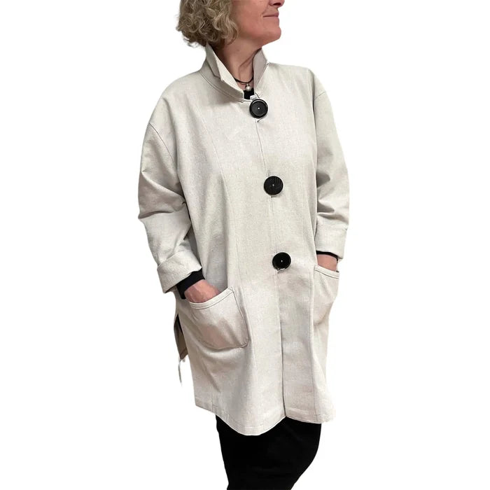 Person wearing a white coat with black buttons on a white background