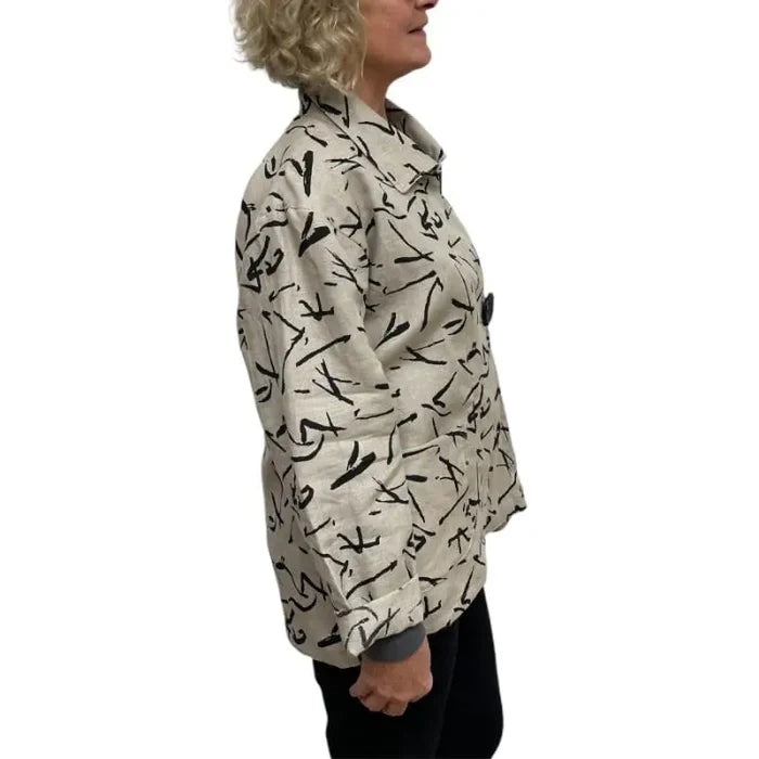 Person wearing a patterned shirt with black abstract designs on a white background