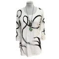 White dress with black abstract patterns on a mannequin against a white background