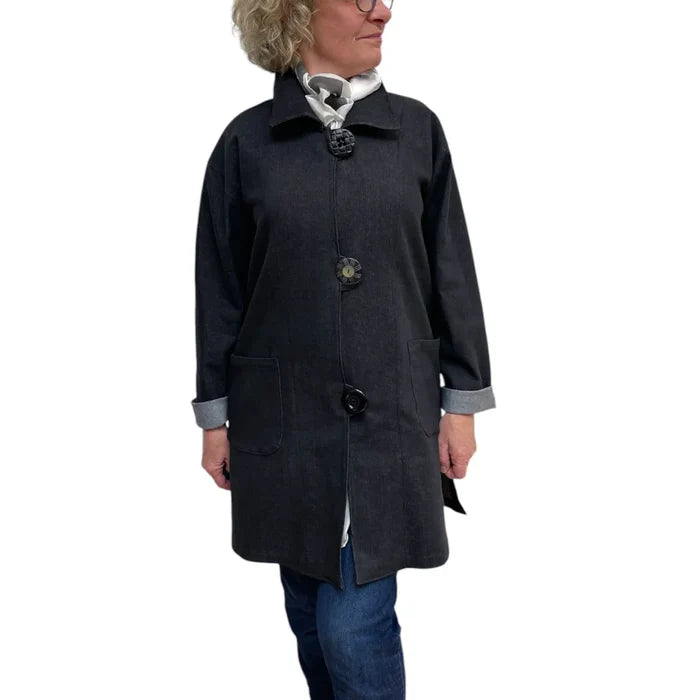 Person wearing a dark gray coat with buttons on a white background