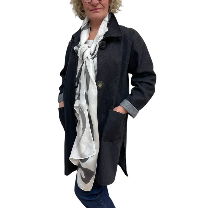 Person wearing a dark coat with a white scarf, on a white background