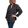 Woman wearing a black patterned shirt on a white background