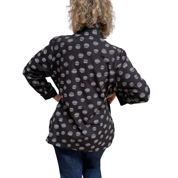 Person wearing a black jacket with white polka dot pattern on a white background