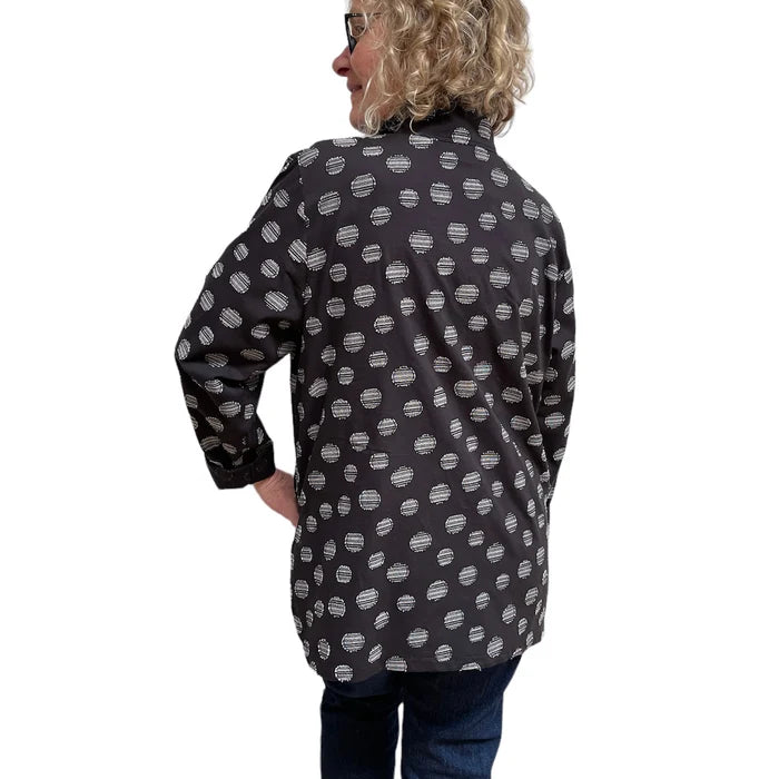 Person wearing a black patterned shirt on a white background