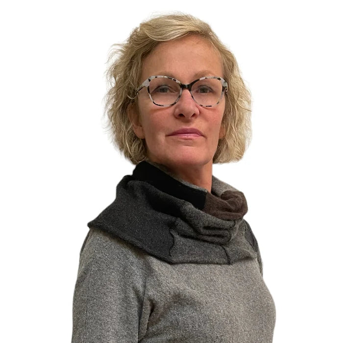 Woman wearing a gray sweater with a dark scarf on a white background
