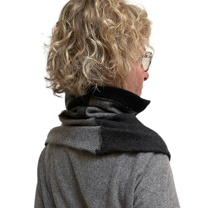 Person wearing a gray coat with a black collar against a white background