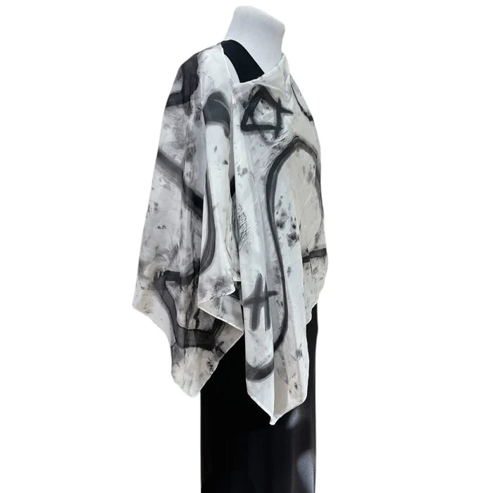 Mannequin wearing a black and white abstract patterned scarf on a white background