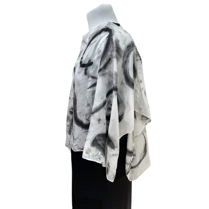 Mannequin wearing a black and white abstract patterned kimono-style garment on a white background