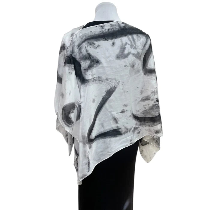 Mannequin wearing a black and white abstract patterned top on a white background