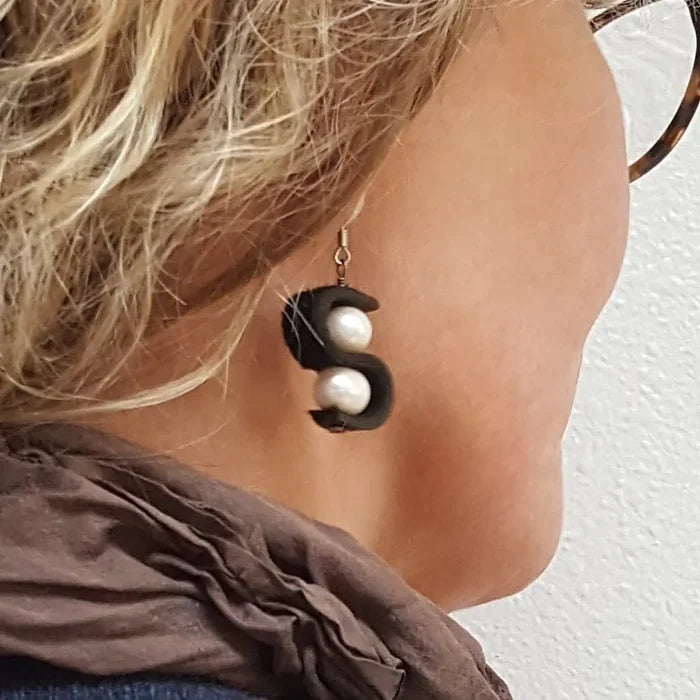 Close-up of a person wearing a unique earring with a black and white design.
