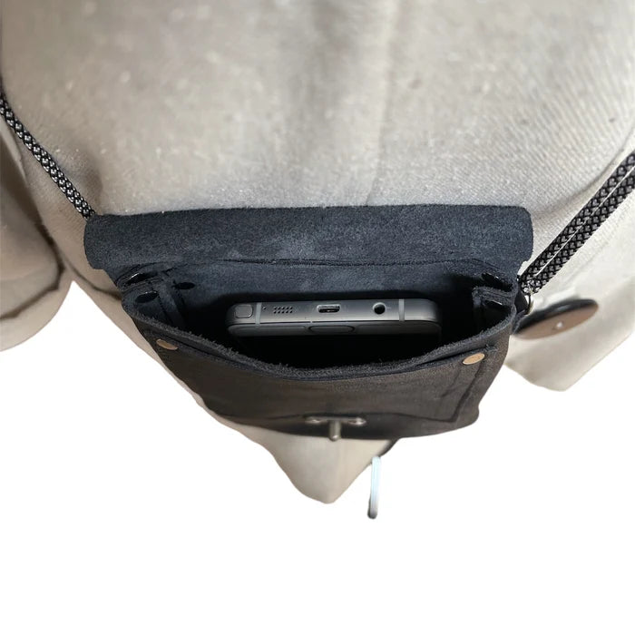 Close-up of a backpack with a phone in a pocket on a plain background