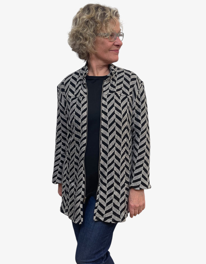 Woman wearing a black and white patterned jacket on a white background