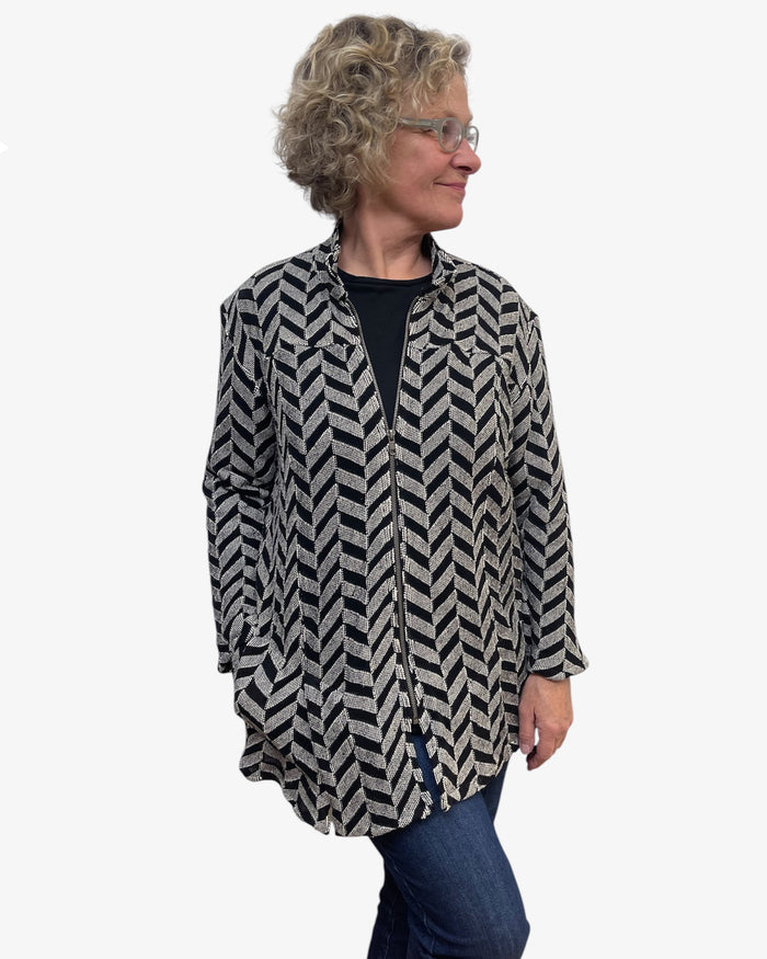 Woman wearing a patterned shirt and jeans on a white background