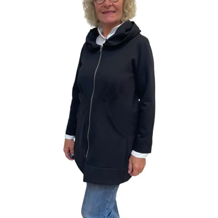 Person wearing a black hooded jacket on a white background