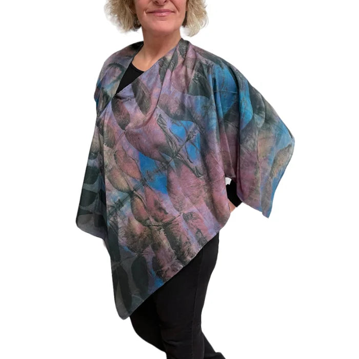 Woman wearing a colorful patterned shawl on a white background