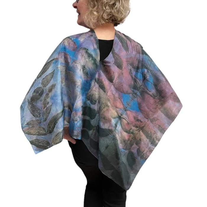 Person wearing a colorful floral-patterned shawl on a white background