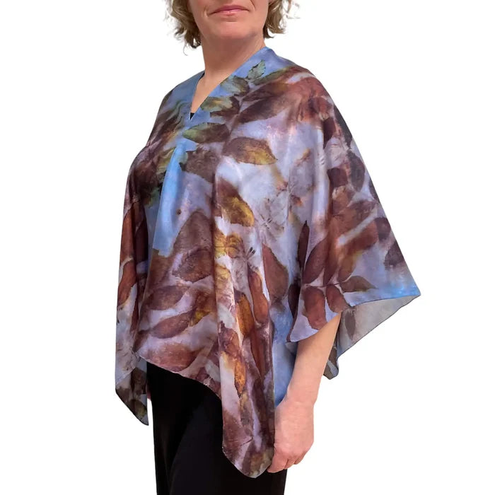 Person wearing a floral patterned poncho against a white background