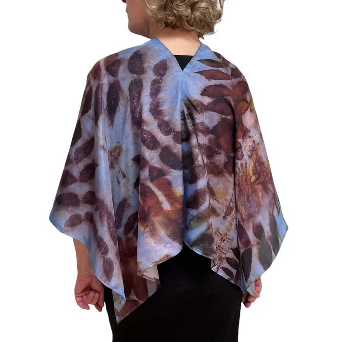 Person wearing a patterned shawl on a white background