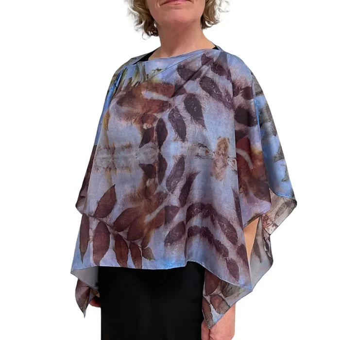 Woman wearing a floral patterned poncho on a white background