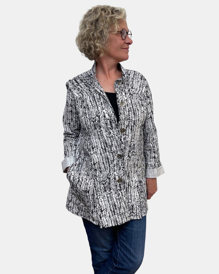 Woman wearing a patterned jacket on a white background
