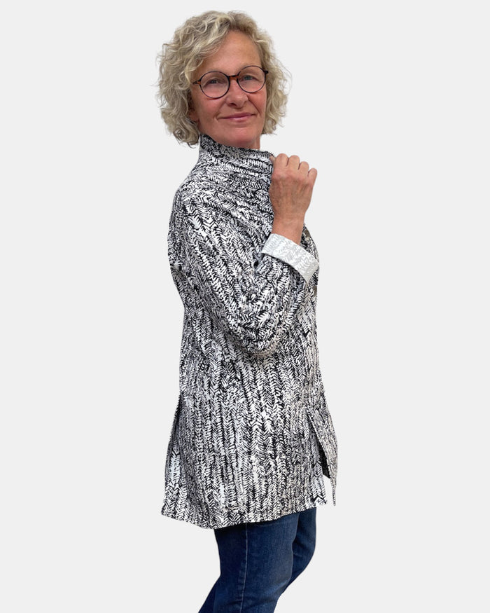 Woman wearing a patterned shirt and glasses on a white background