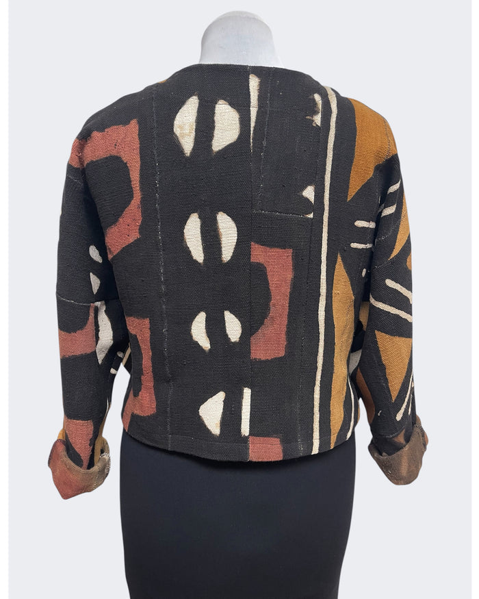 Mannequin wearing a patterned jacket with geometric design on a white background