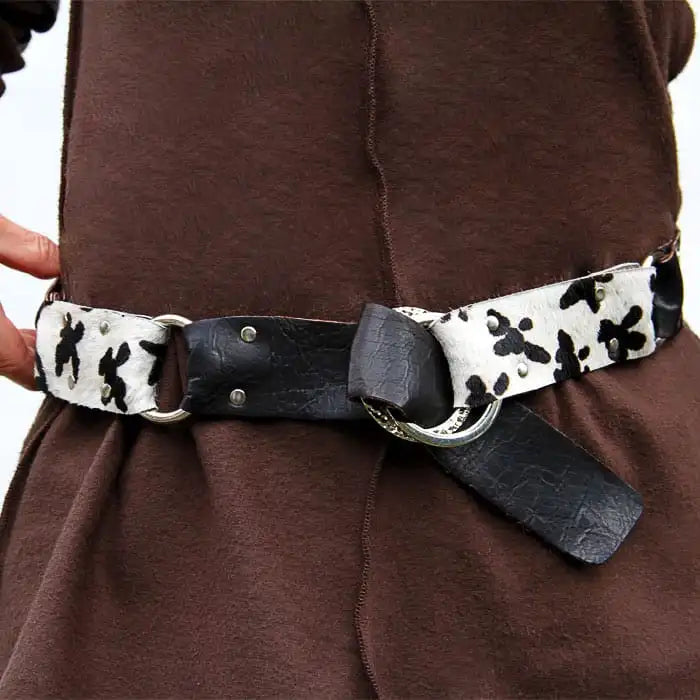 Person wearing a brown garment with a black and white patterned belt.