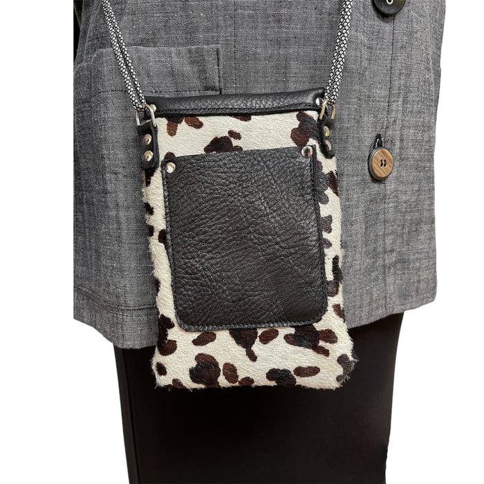 Leopard print crossbody bag with a black pocket attached to a gray jacket.