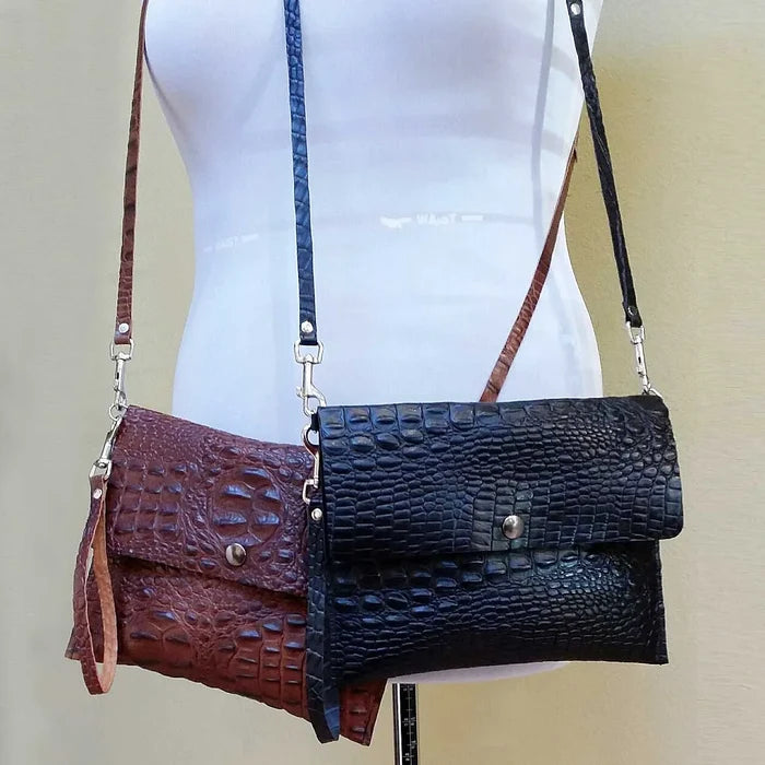 Two leather handbags, one brown and one black, on a mannequin with a beige background.