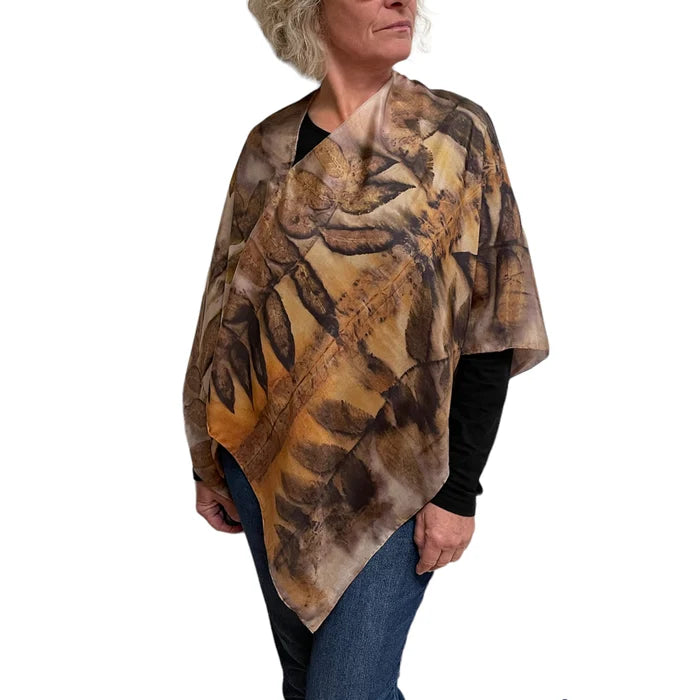 Woman wearing a brown patterned poncho on a white background