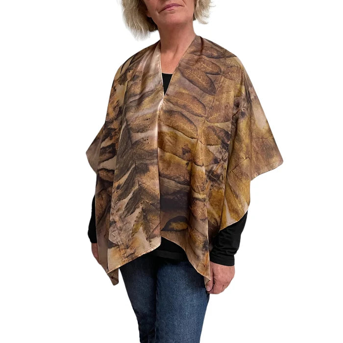 Woman wearing a patterned brown and beige scarf on a white background