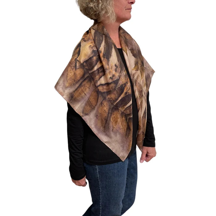 Person wearing a brown and beige patterned scarf on a white background
