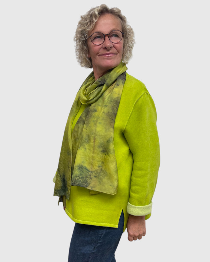 Close up of side slit on chartreuse hand dyed sweatshirt tunic with silk scarf