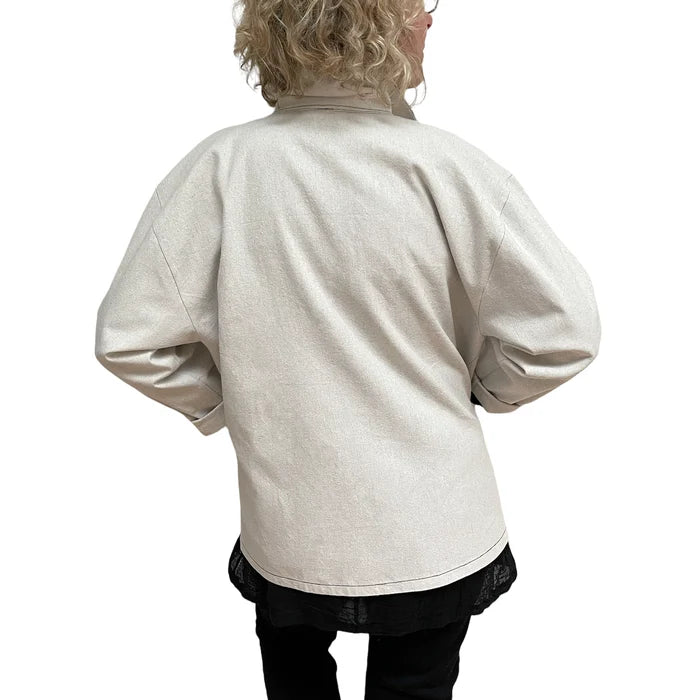 Person wearing a beige jacket on a white background