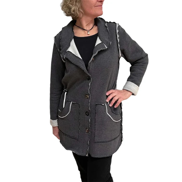 Woman wearing a gray hooded jacket with white accents on a white background