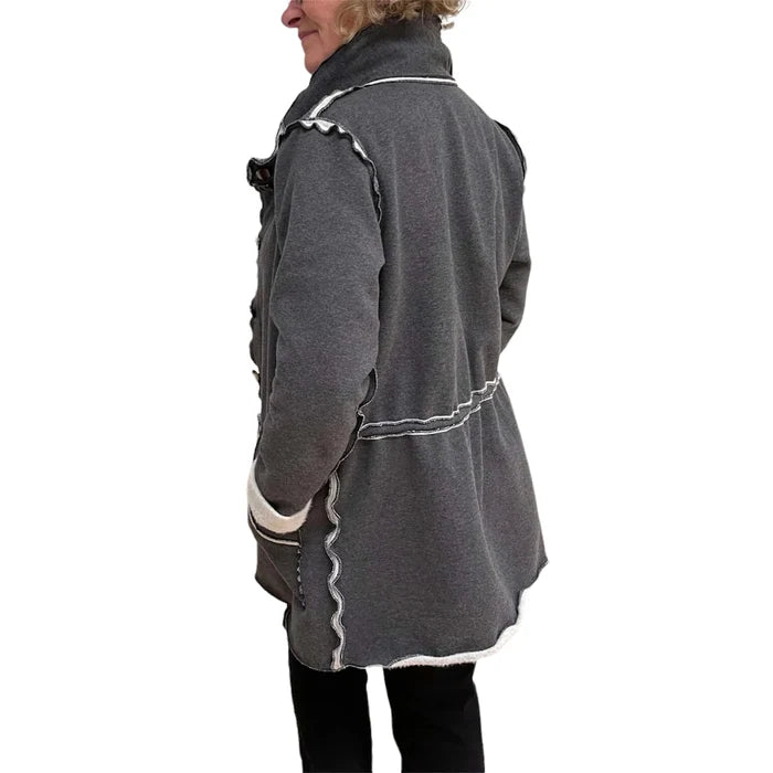 Gray coat with white trim worn by a person on a white background
