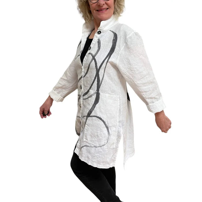 Woman wearing a white shirt with black abstract designs on a white background