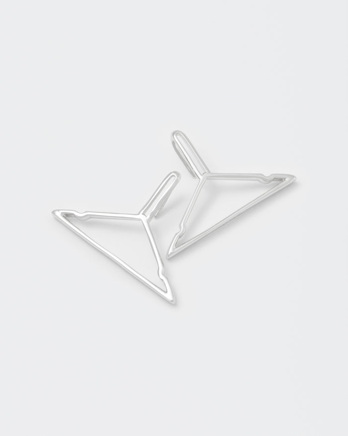 detail of hanger shaped earrings with 18kt white gold coating, silver 925 pin and engraved logo.