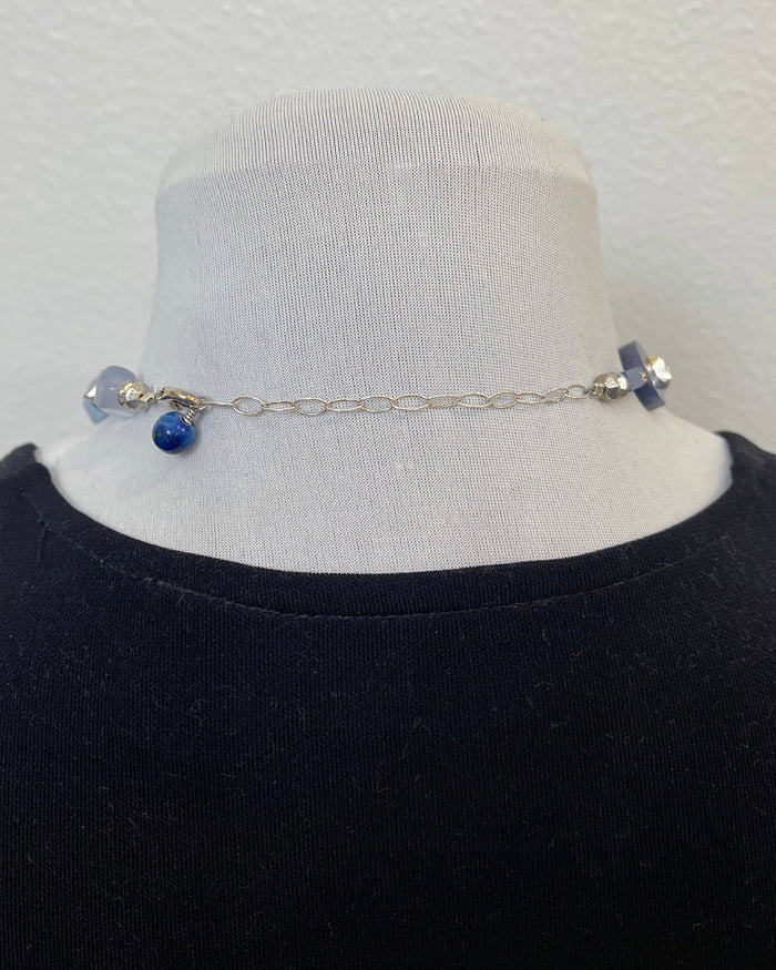 Necklace with blue beads on a mannequin against a white background