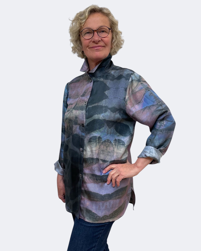 Woman wearing a patterned shirt against a plain background