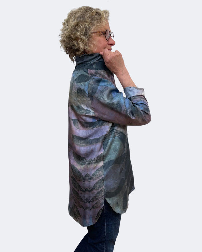 Person wearing a patterned shirt on a white background