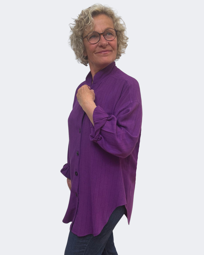 Person wearing a purple shirt on a white background