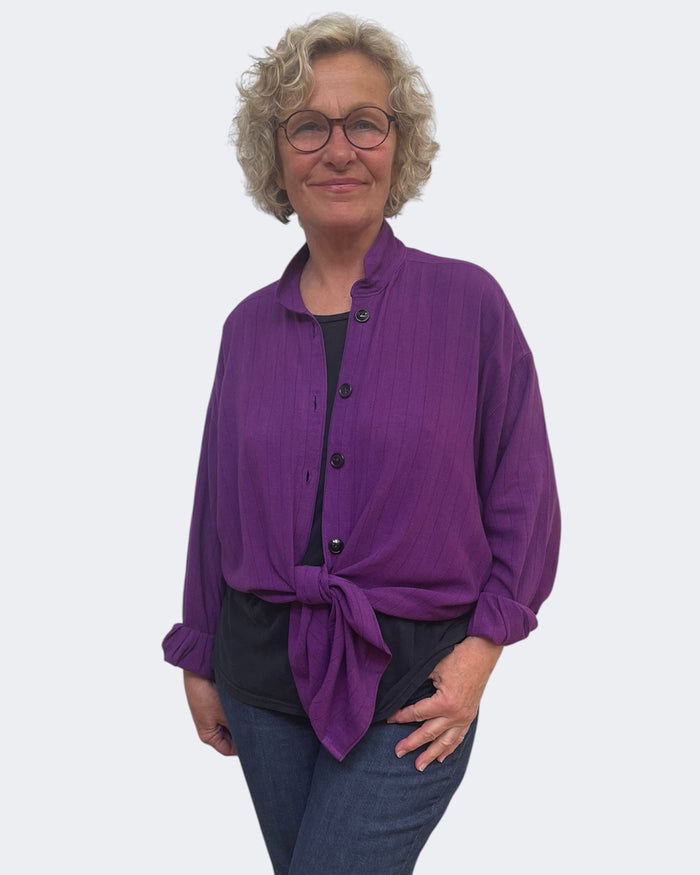 Woman wearing a purple shirt with a white background