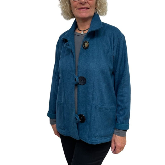 Woman wearing a blue jacket with button details on a white background