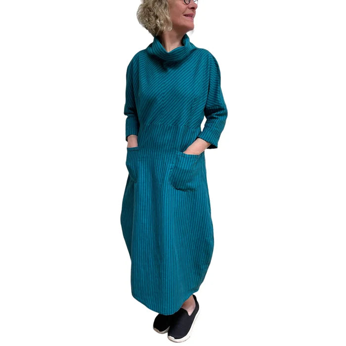 Woman wearing a teal ribbed dress on a white background