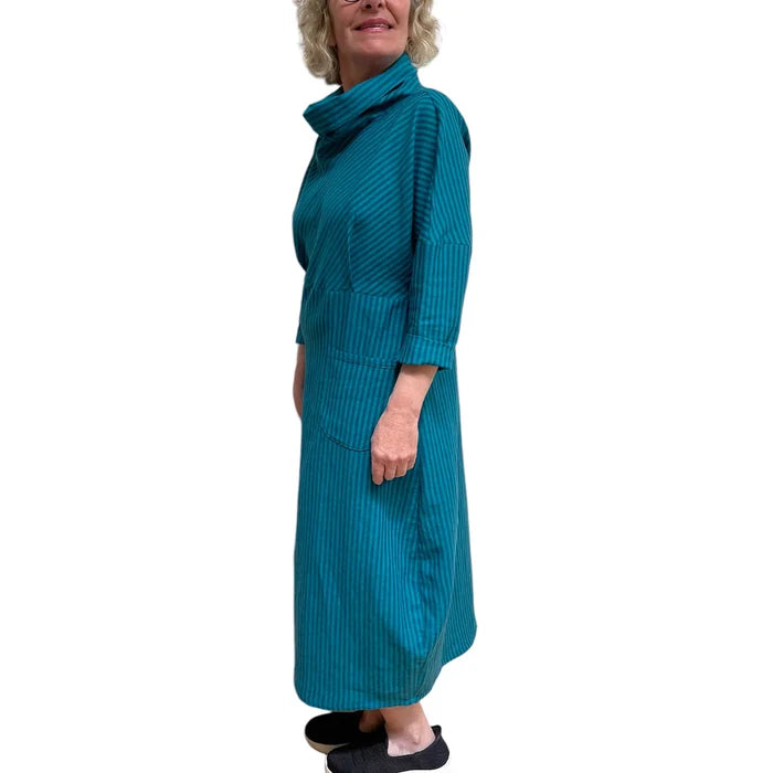 Woman wearing a teal ribbed dress on a white background